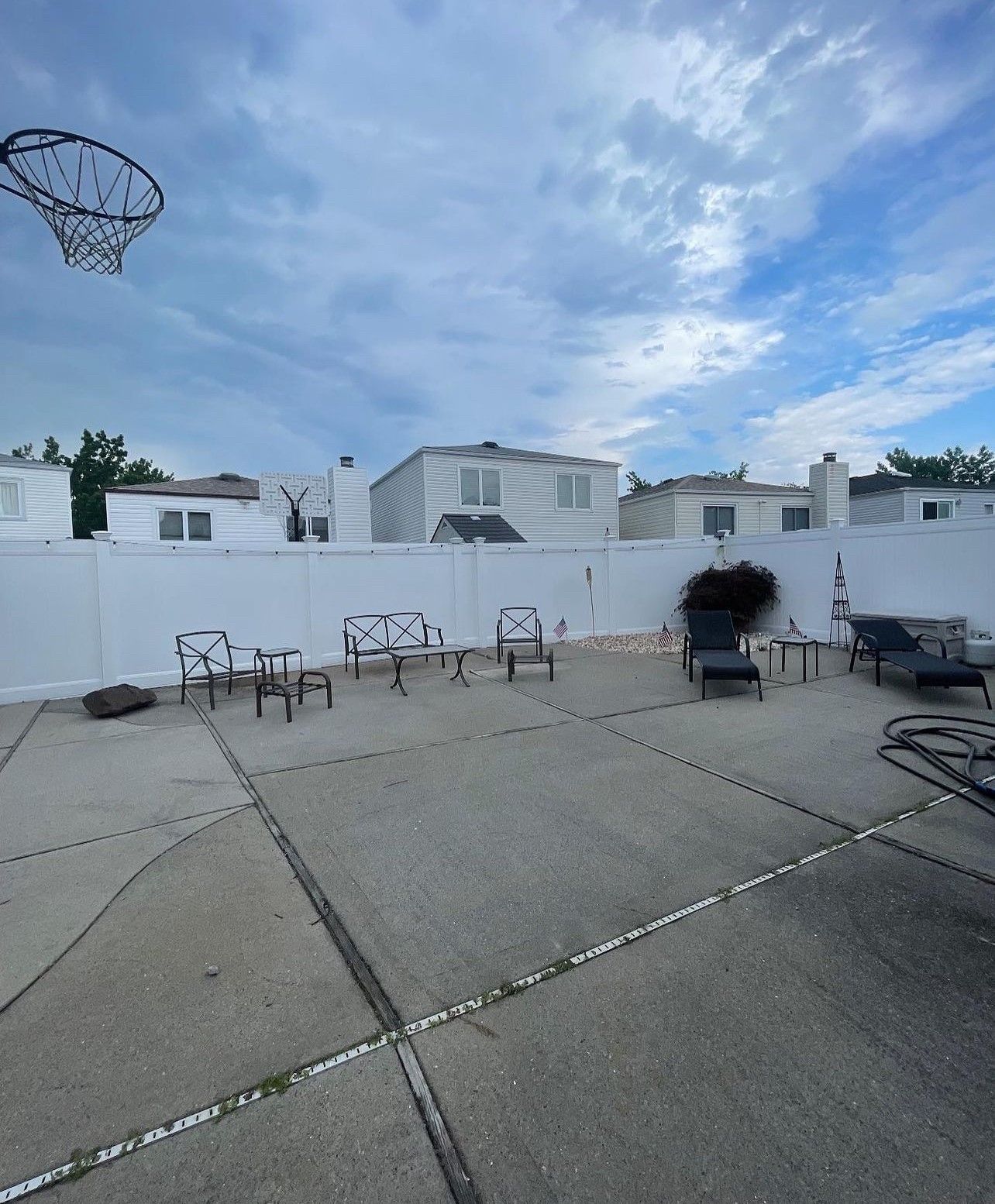 A backyard with a basketball hoop and chairs