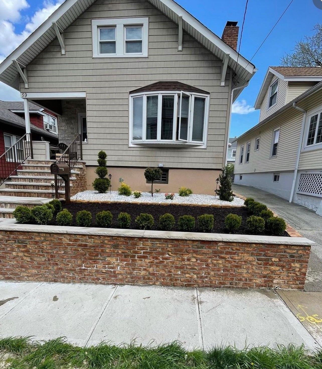 A house with a brick wall in front of it