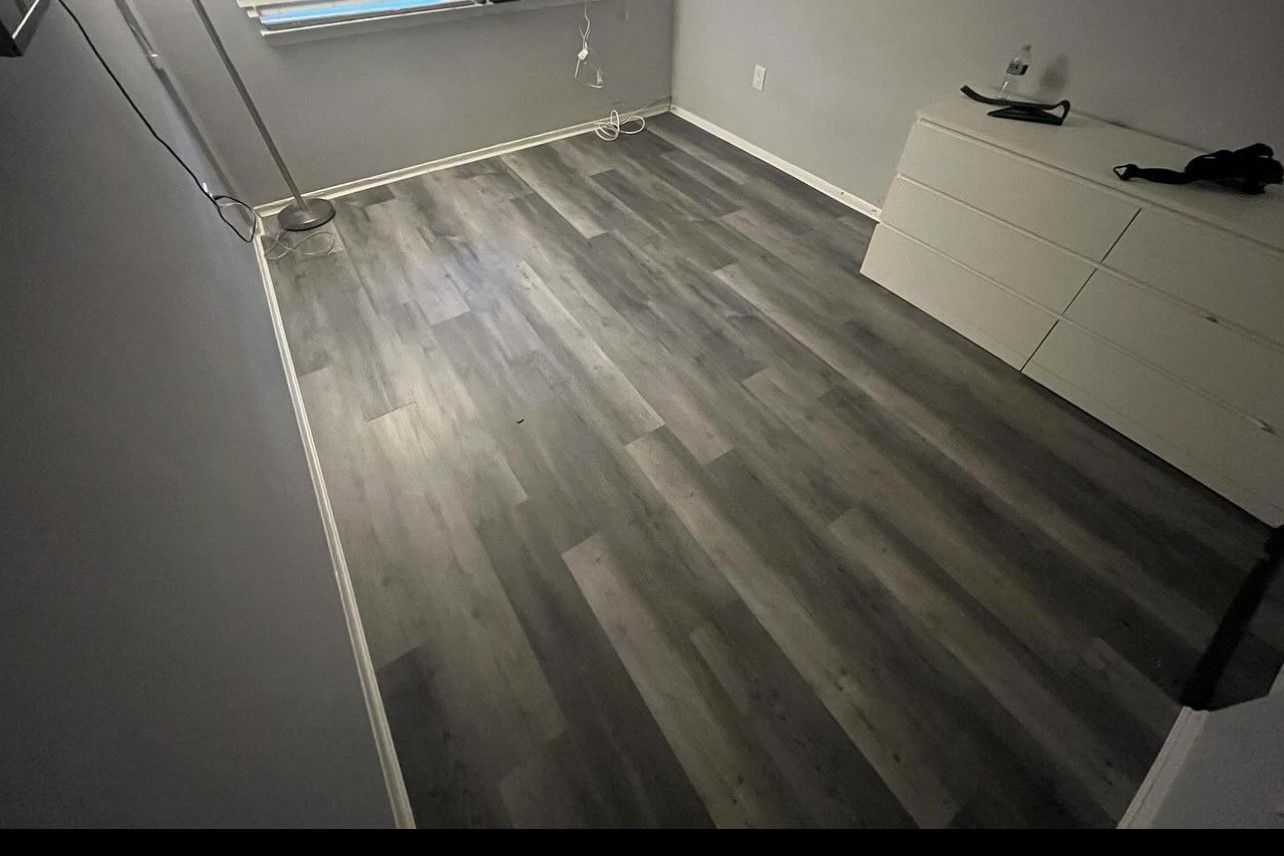 A room with a wooden floor and a window.