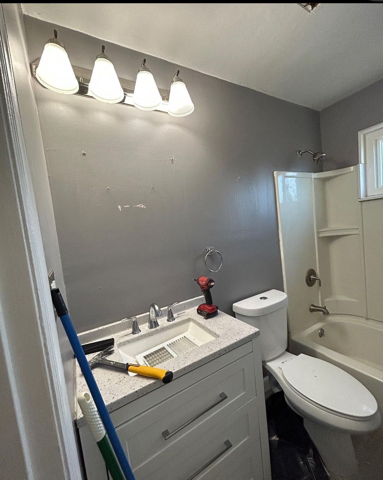 A bathroom with a sink , toilet , tub and mirror