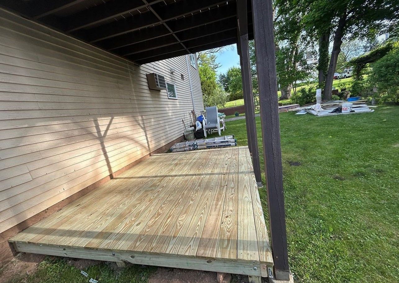 A wooden deck is being built in the backyard of a house.
