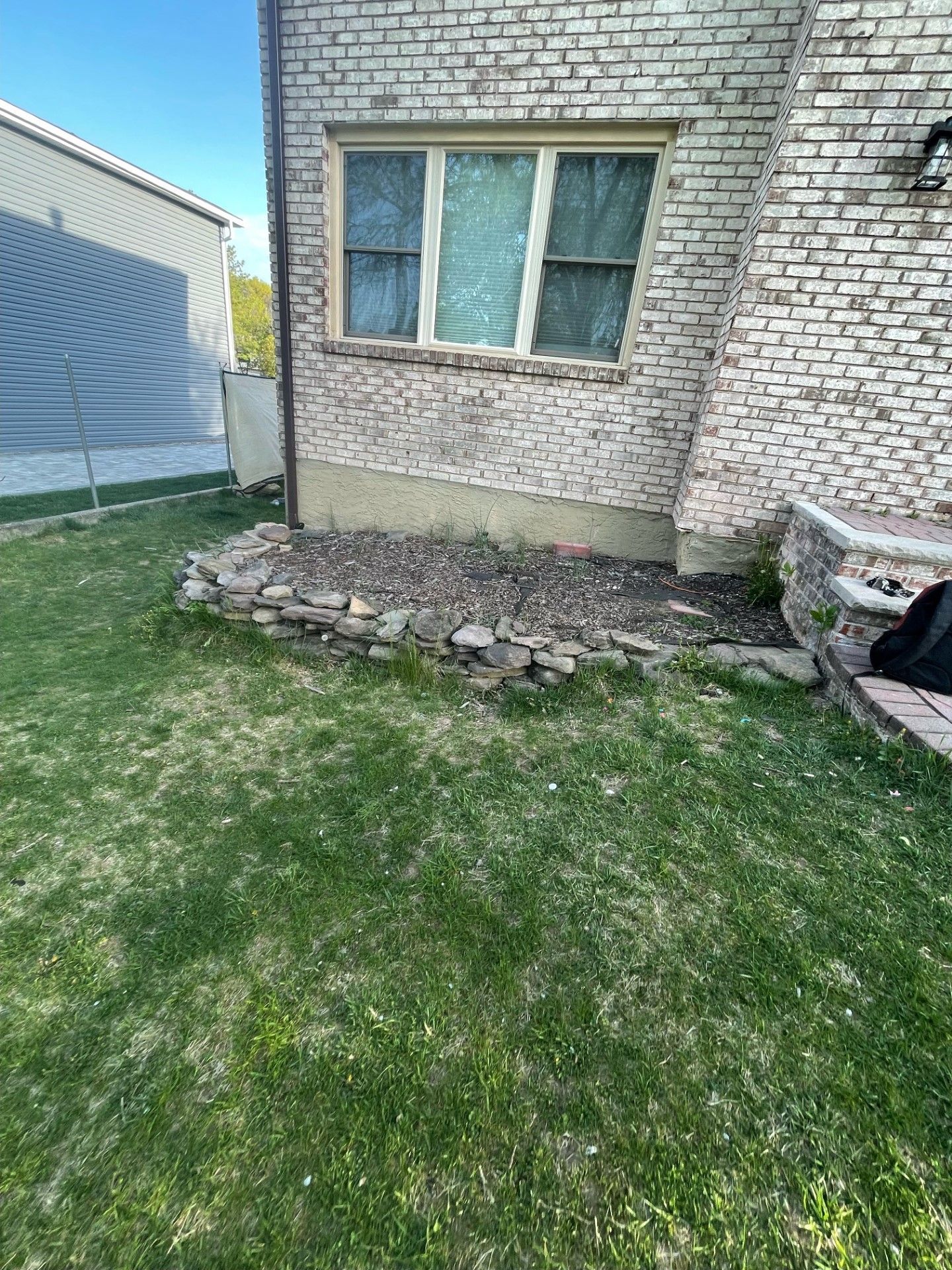 A brick building with a window in the backyard of a house.
