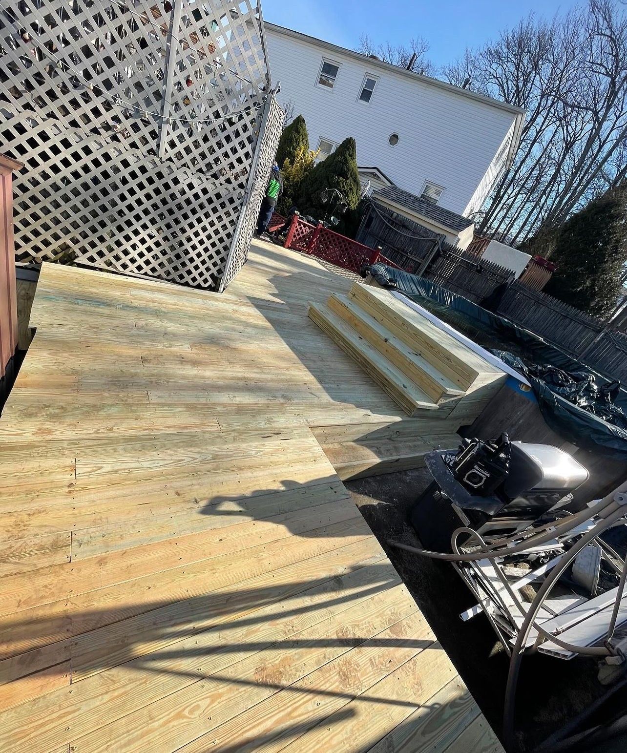 A wooden deck is being built in a backyard.