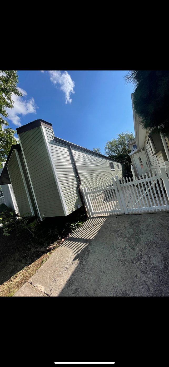 A white trailer is parked in front of a house.