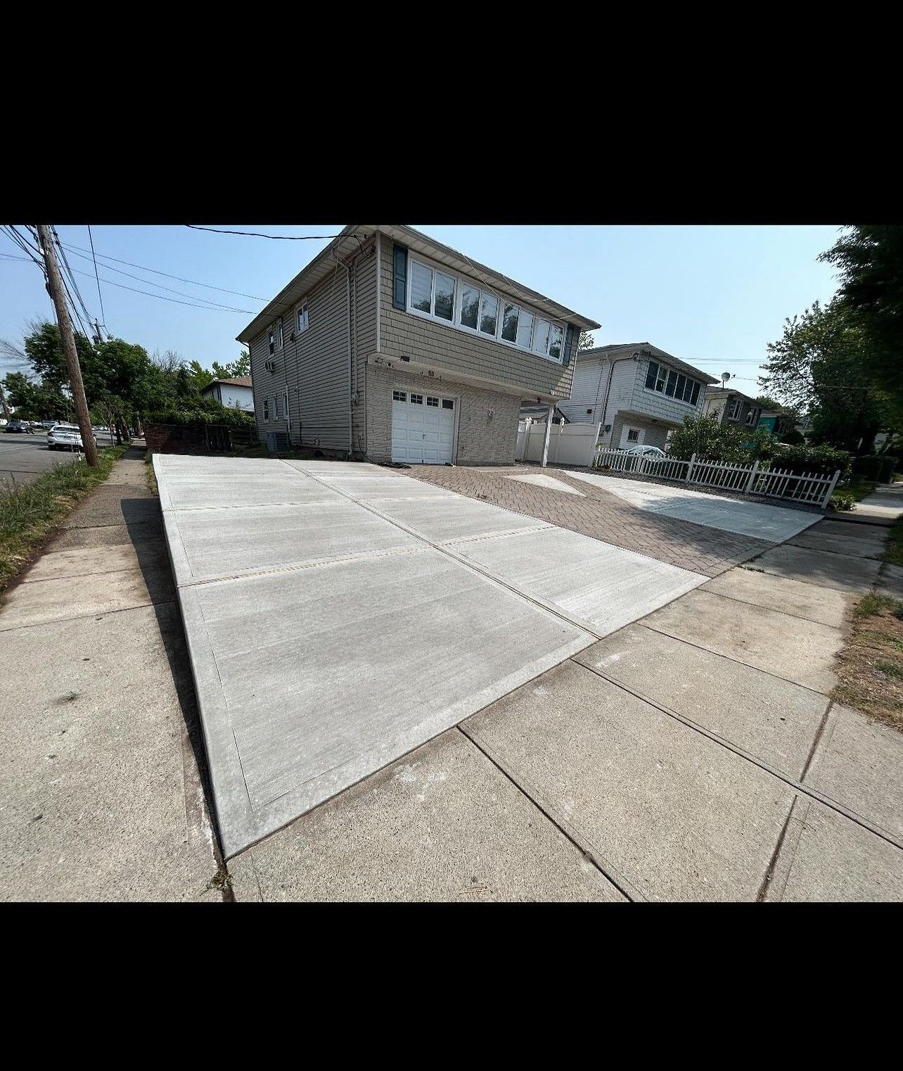 A large house with a concrete driveway in front of it.