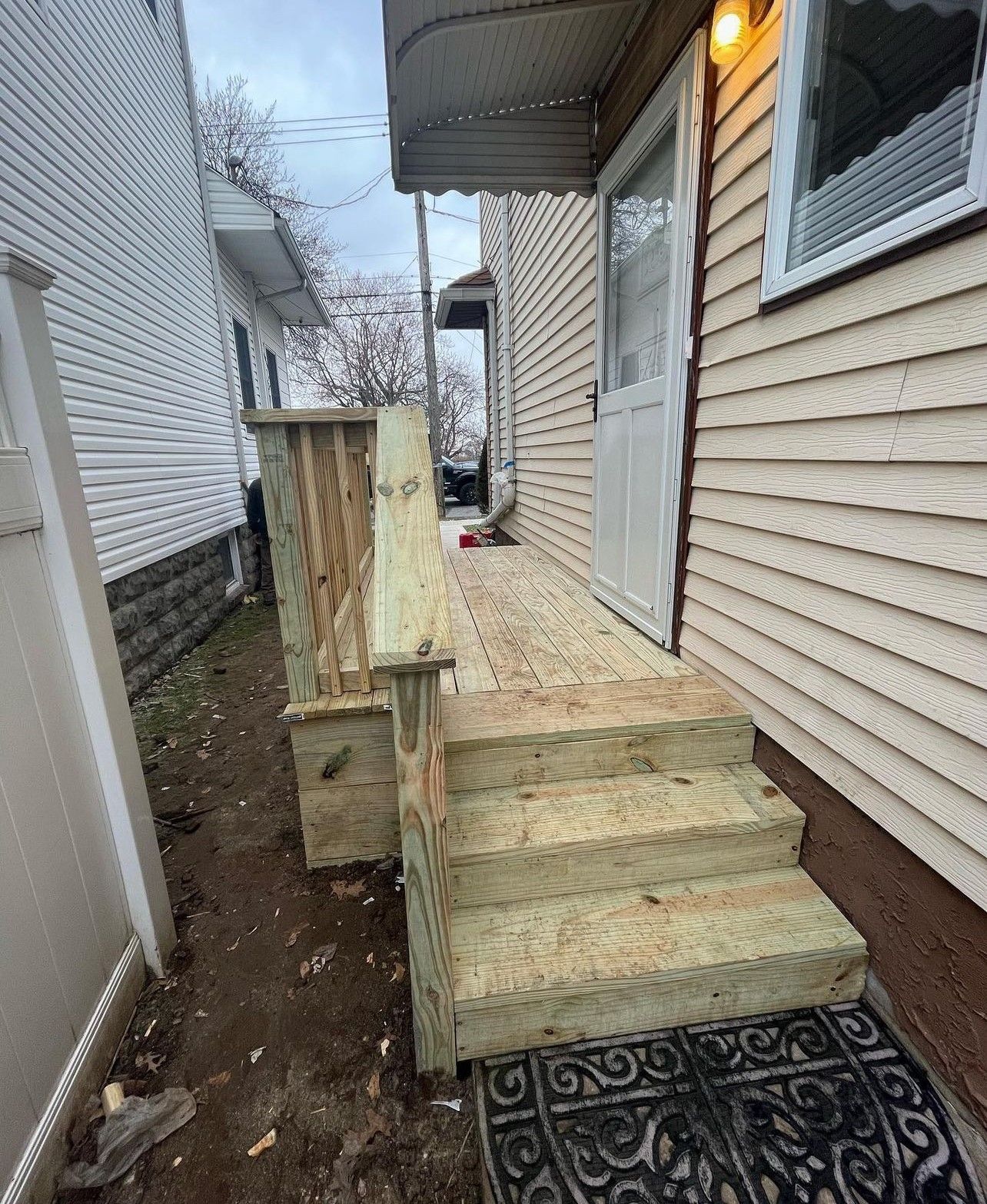 A wooden deck is being built on the side of a house.