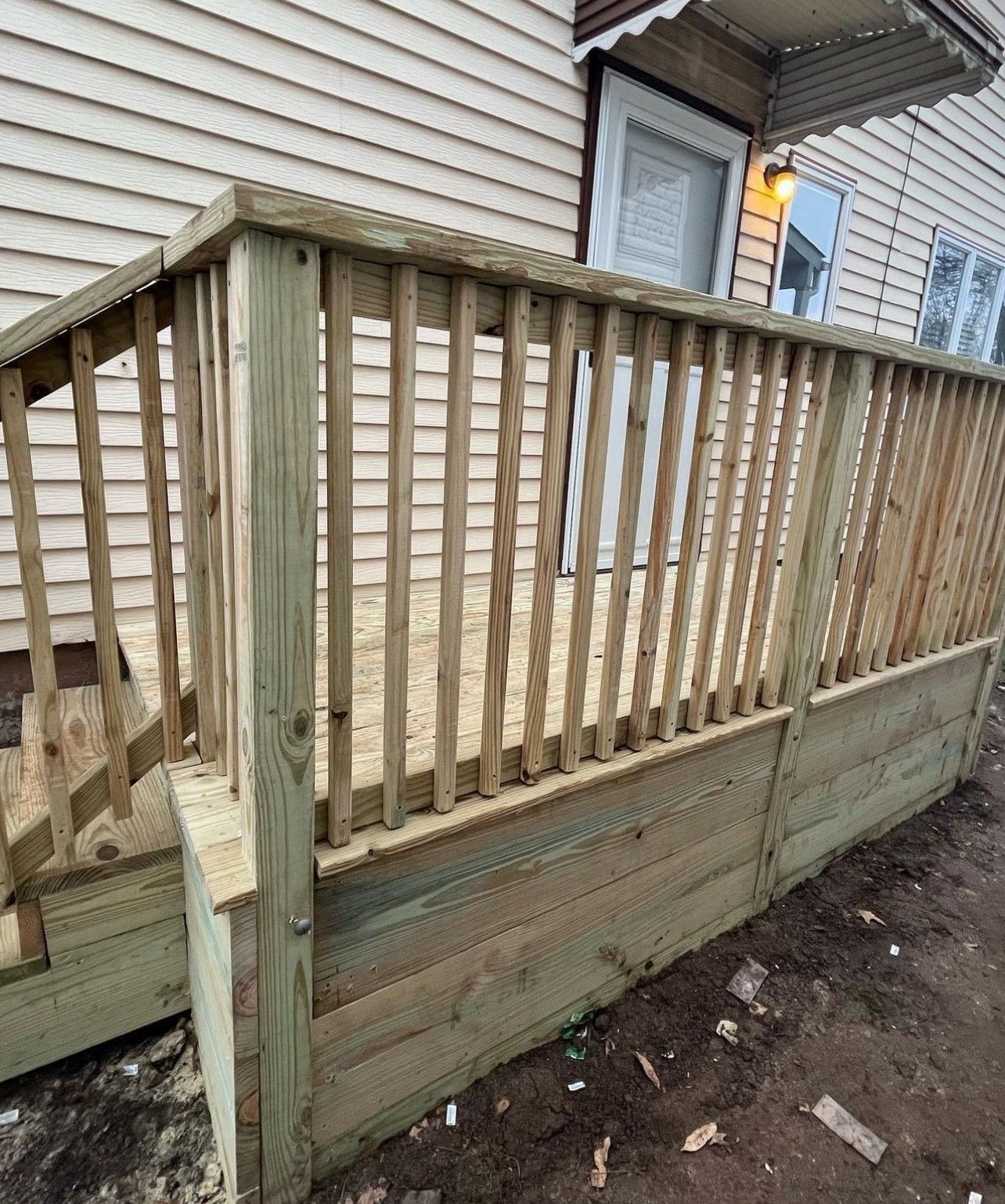 A wooden deck is being built in front of a house.