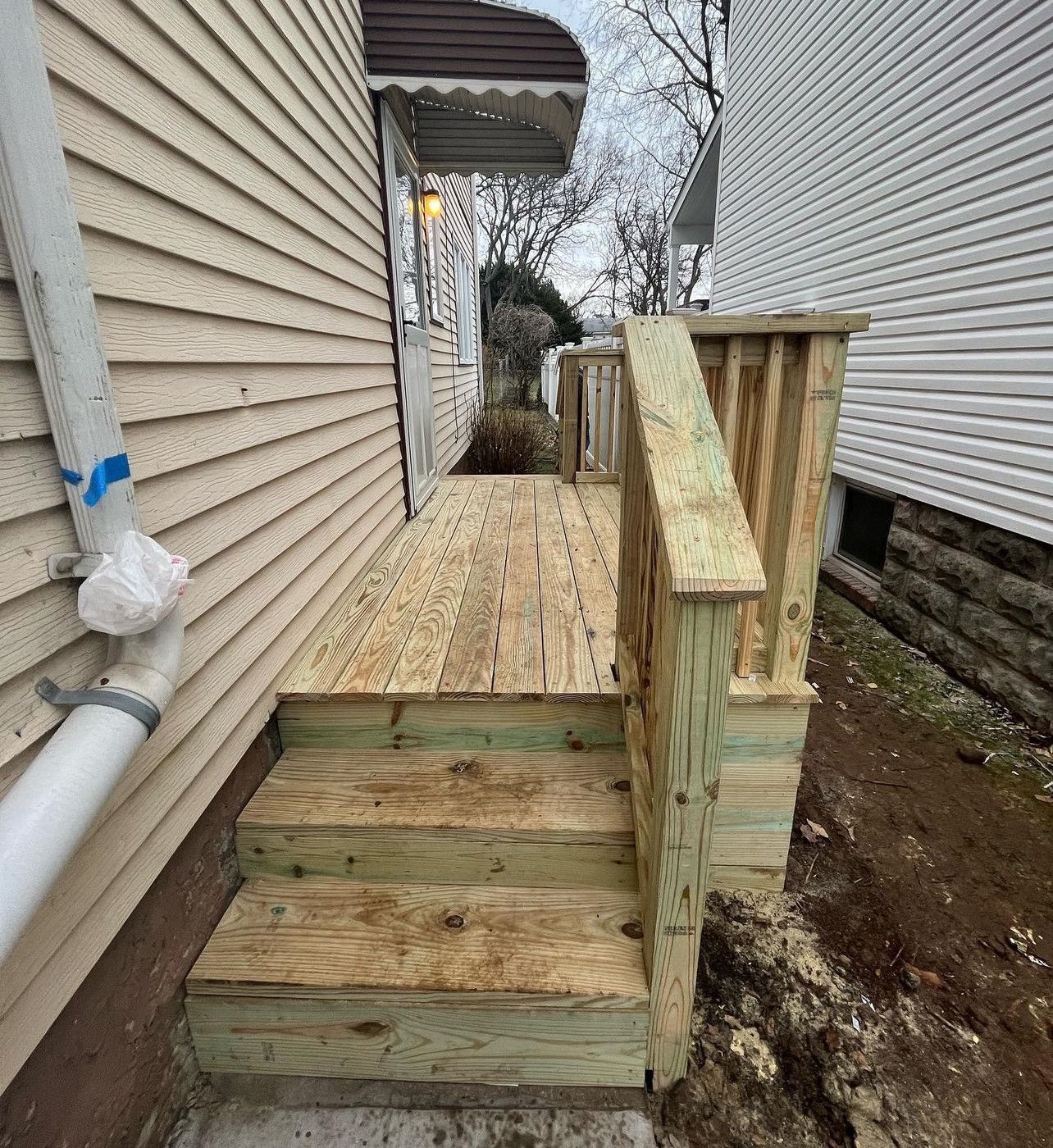 A wooden deck is being built on the side of a house.