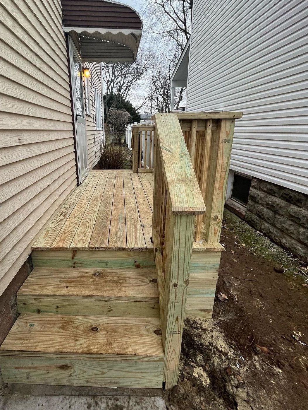 A wooden deck is being built on the side of a house.