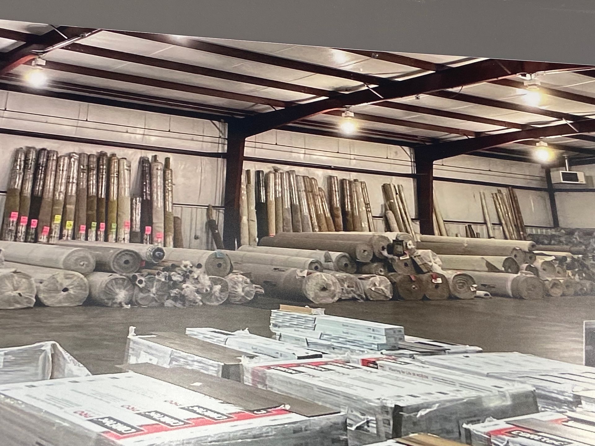 A large warehouse filled with lots of rolls of carpet