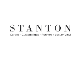 The logo for stanton carpet , custom rugs , runners , luxury vinyl.