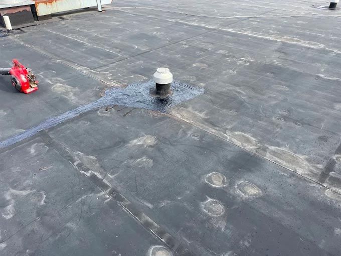 A roof with a hole in it and a vacuum cleaner on it.