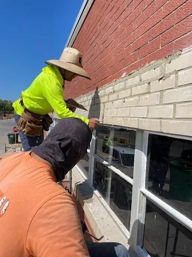 A white house with a window and a wooden roof.