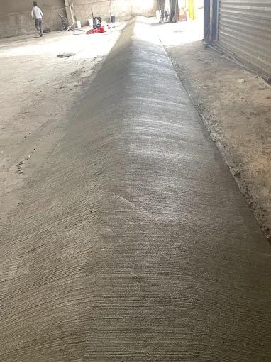 A concrete walkway is being built in a warehouse.