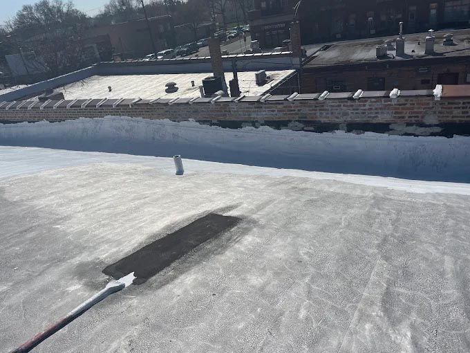 A person is painting a roof with a roller.