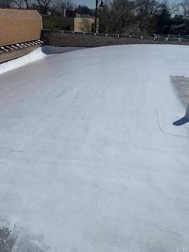 A white roof with a brick wall in the background.
