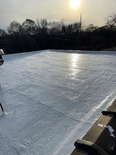 A person is standing on top of a snow covered roof.