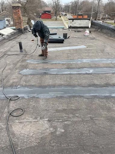 A man is working on a roof with a torch.