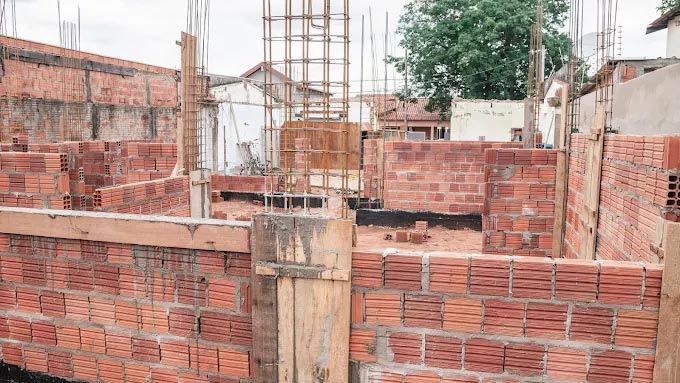 A brick wall is being built in a construction site.