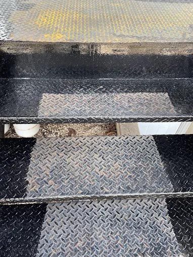 A close up of a metal staircase with a diamond plate.