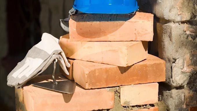A blue hard hat is sitting on top of a pile of bricks.