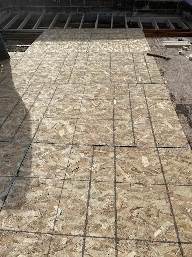 A large piece of plywood is sitting on top of a tiled floor.