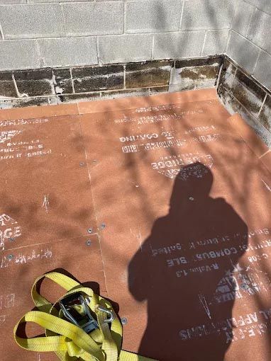A shadow of a person is cast on a tiled floor.