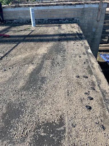 A close up of a concrete roof with a pipe on it.