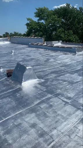 A white house with a window and a wooden roof.