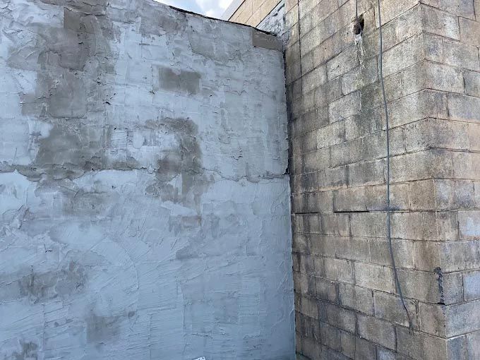 A corner of a brick wall with a hole in it.