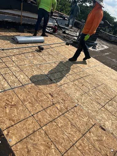 A group of construction workers are working on a roof.