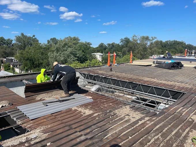 A group of men are working on the roof of a building.