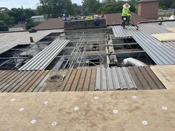 A group of people are working on the roof of a building.