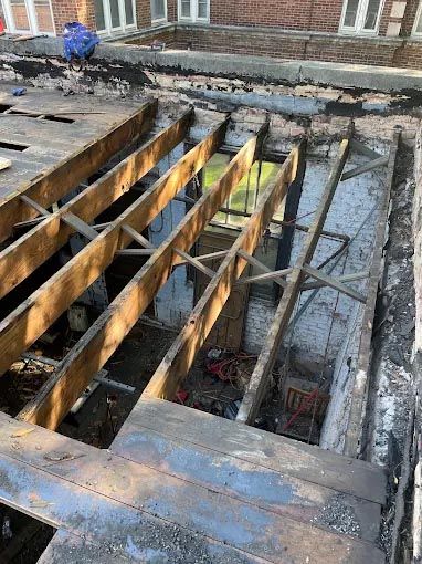 A white house with a window and a wooden roof.
