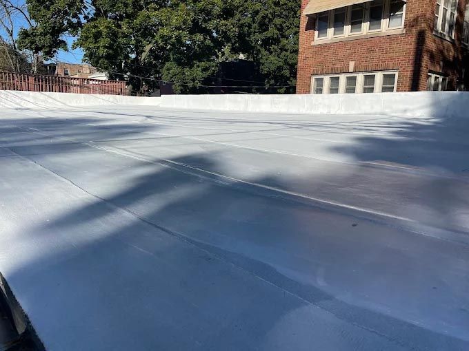 A white roof with a brick building in the background.