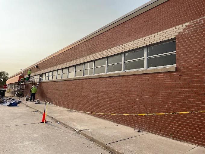 A group of people are painting a brick building.