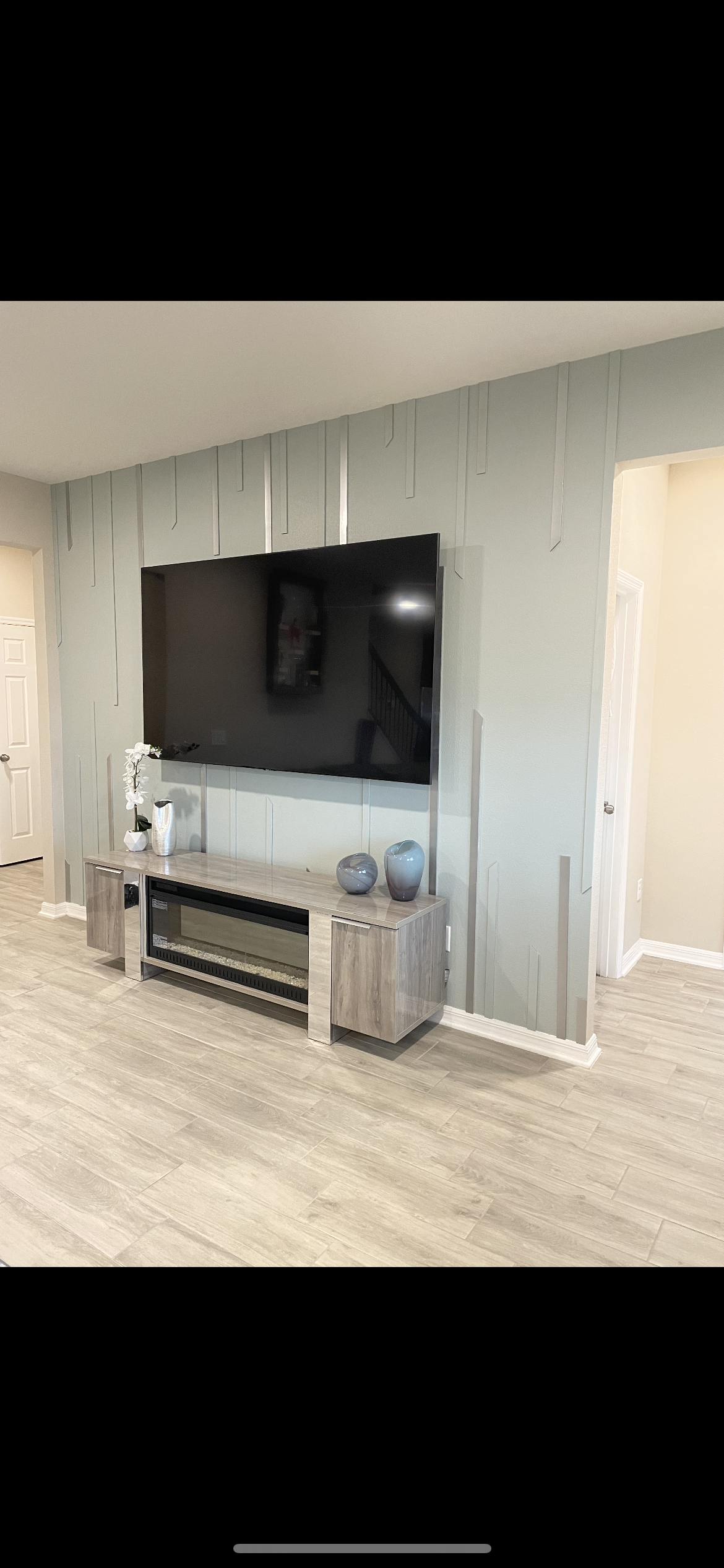 A living room with a flat screen tv mounted on the wall.