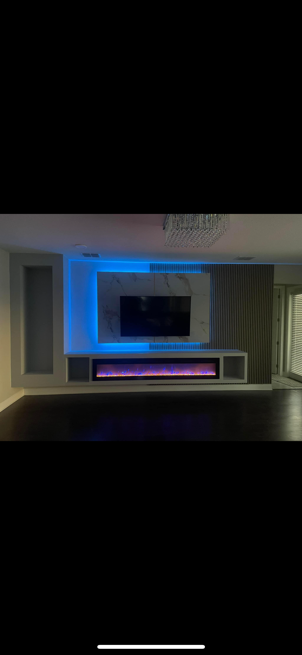 A living room with a fireplace and a flat screen tv.