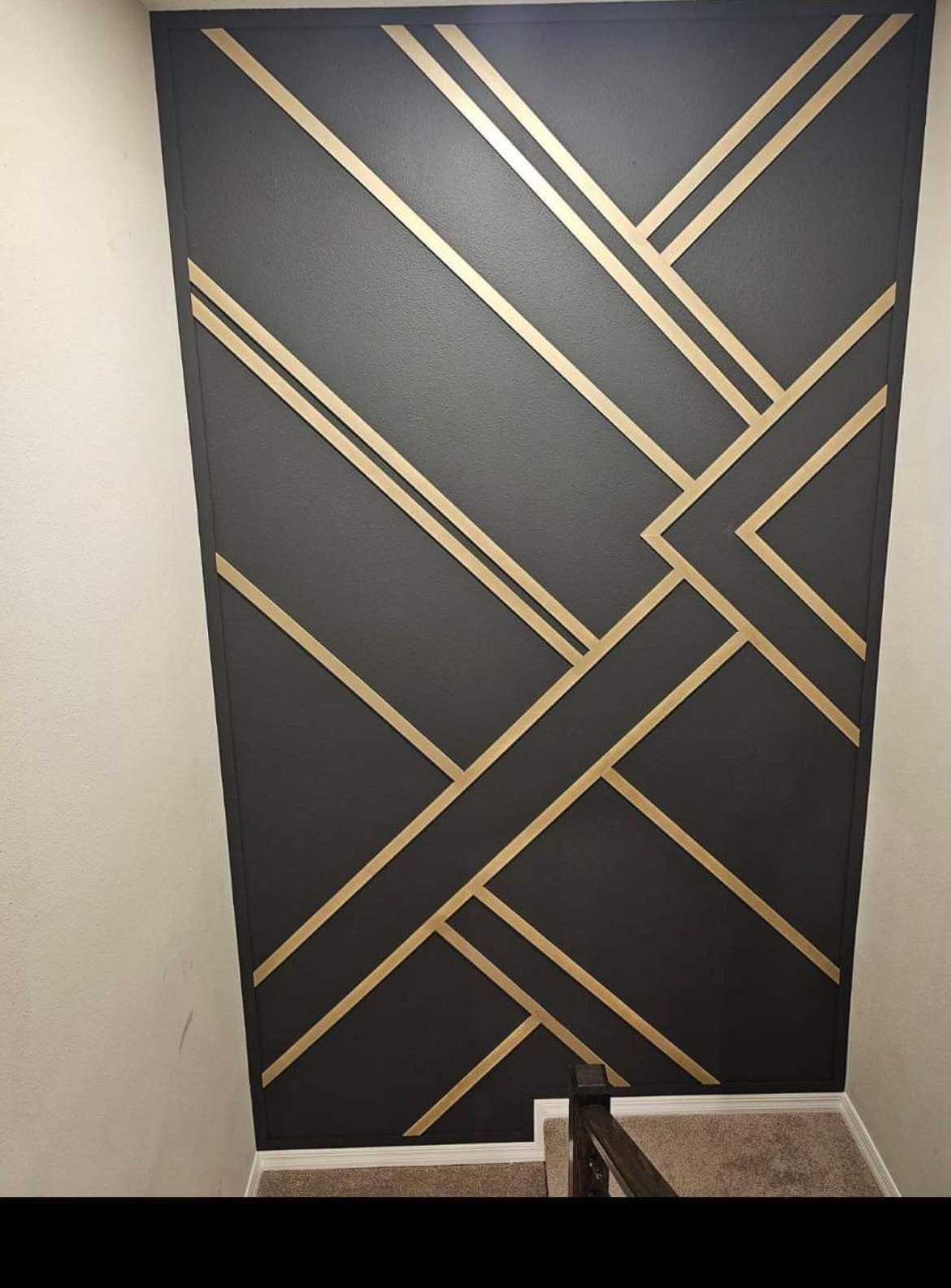 A black wall with gold stripes painted on it.