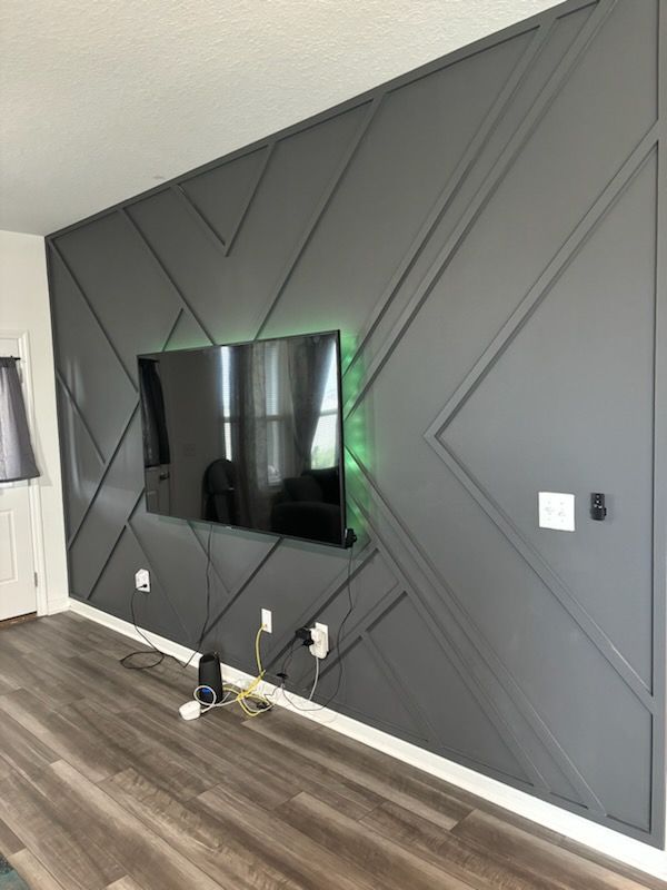 A living room with a flat screen tv mounted to the wall.