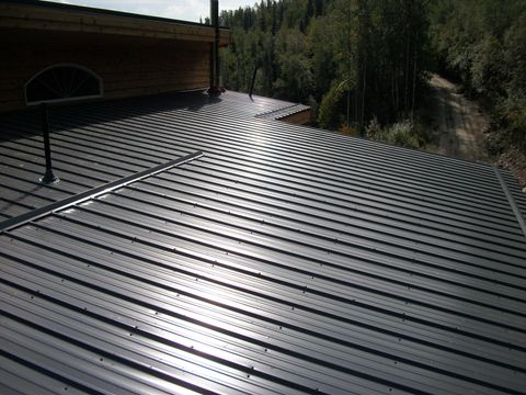 Man installing shingles on roof