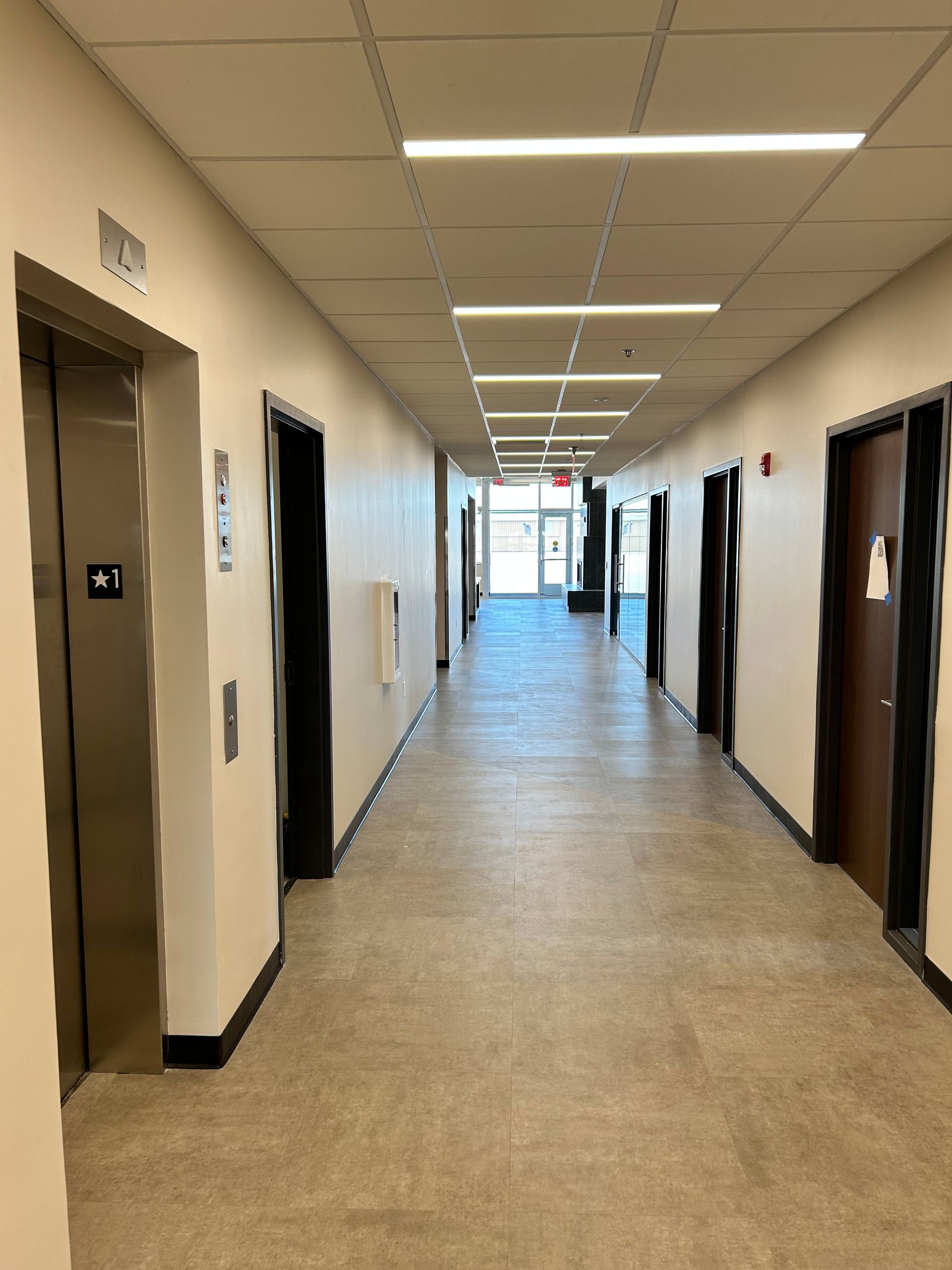 a long hallway with elevators and doors in a building . | Sioux City, IA | L&L Builders Co