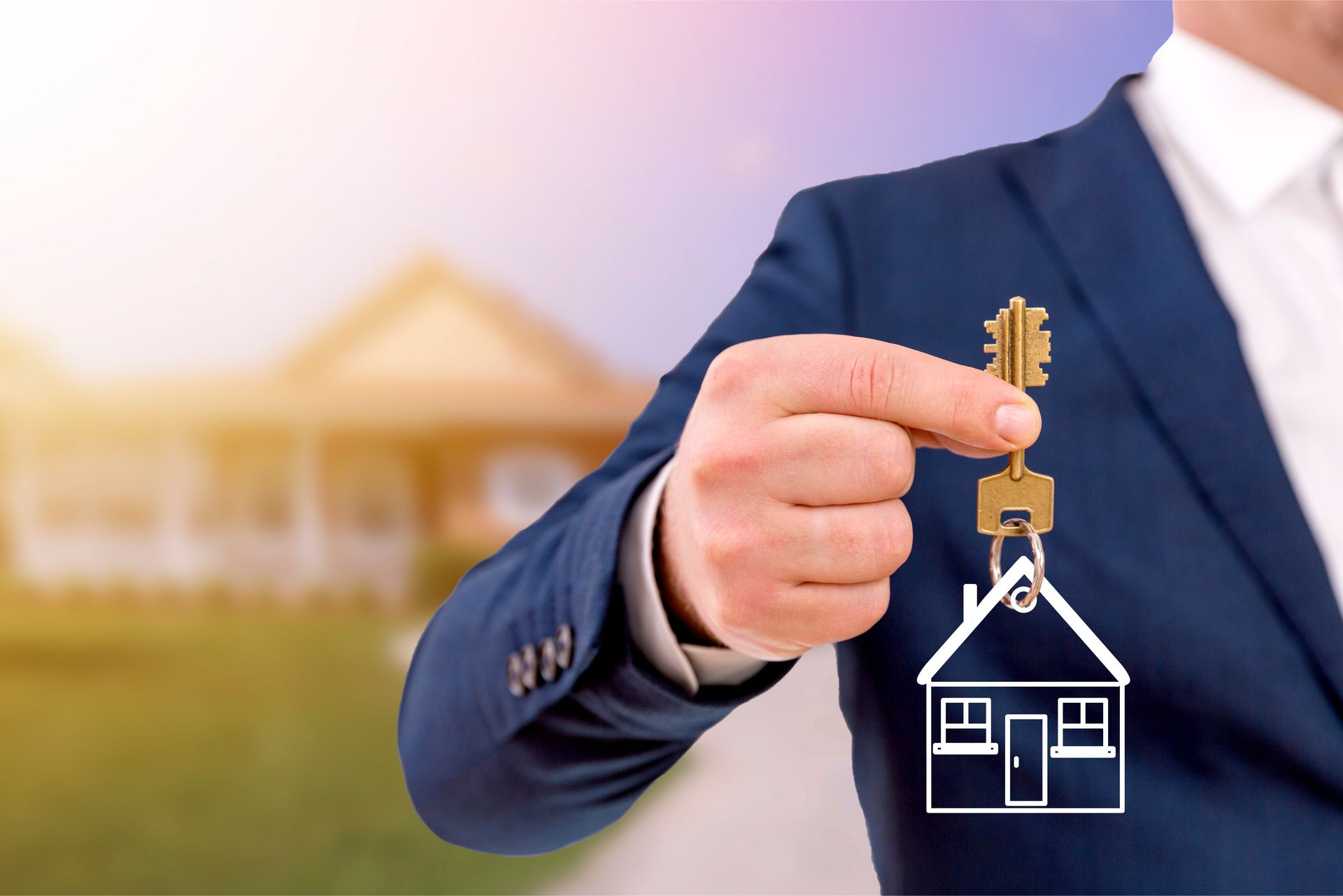 Businessman holding house keys with a home icon, symbolizing real estate purchase.