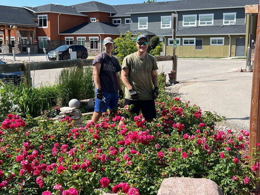 A yellow house with a white garage door featuring a gravel driveway under construction on a clear, sunny day.