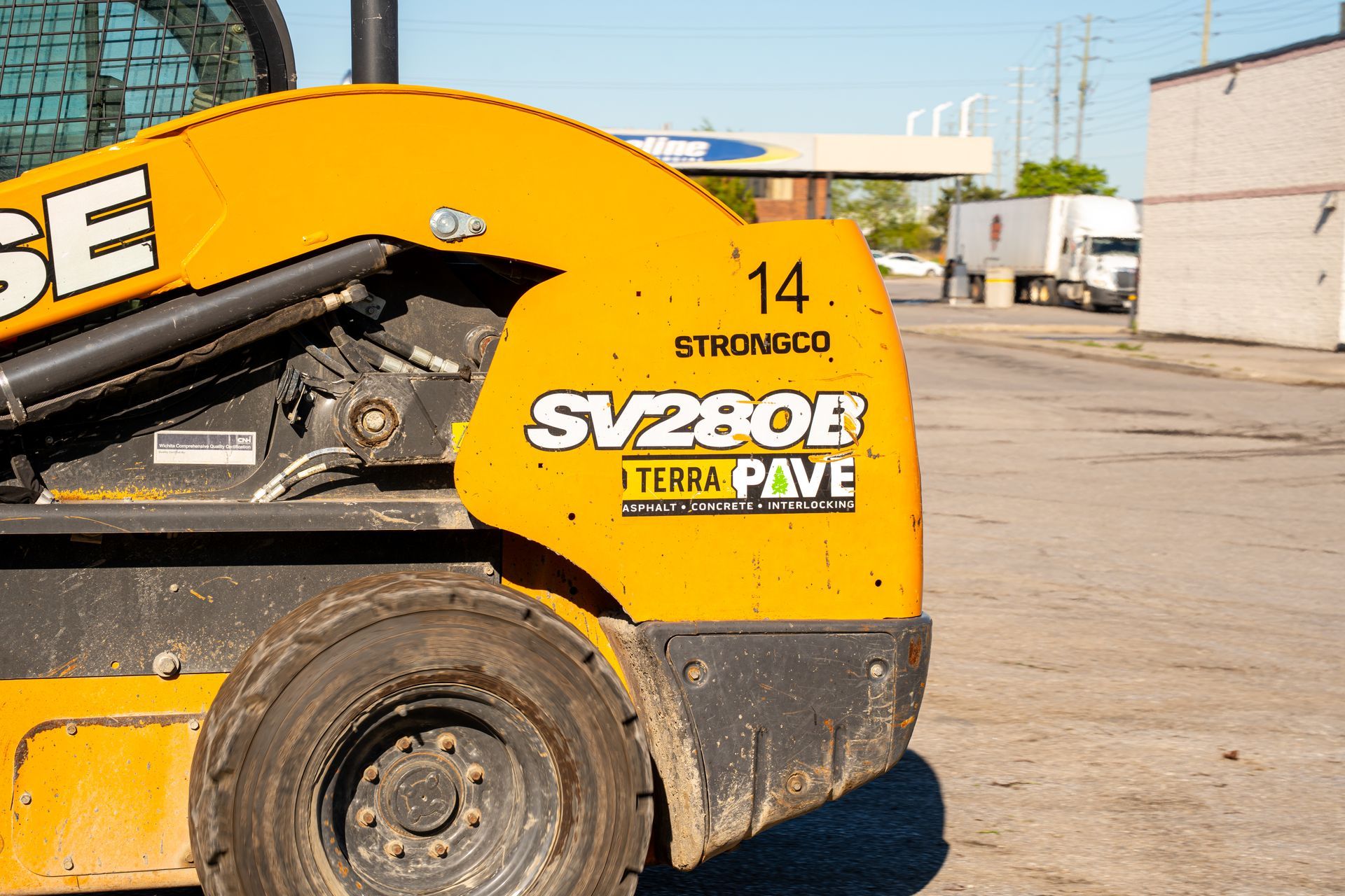 A yellow case sv280b skid steer is parked in a parking lot