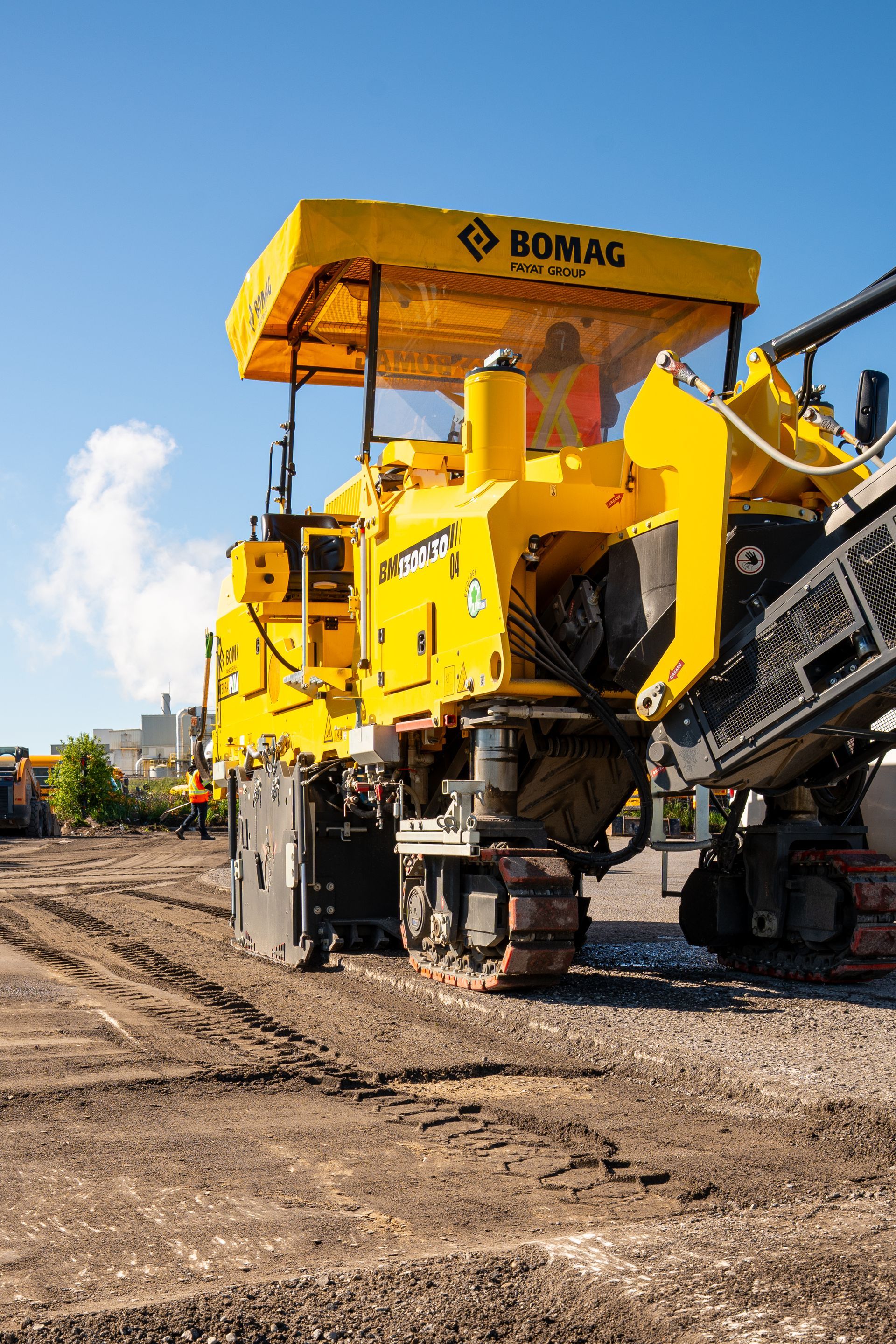 A yellow and black machine is sitting on top of a dirt field.