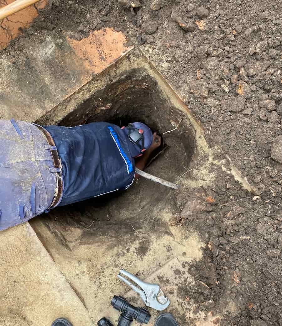 A Person Is Digging A Hole In The Ground With A Shovel — Plumbmasters In Burleigh Heads, QLD