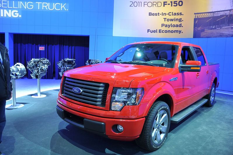 A red ford truck is on display at a car show