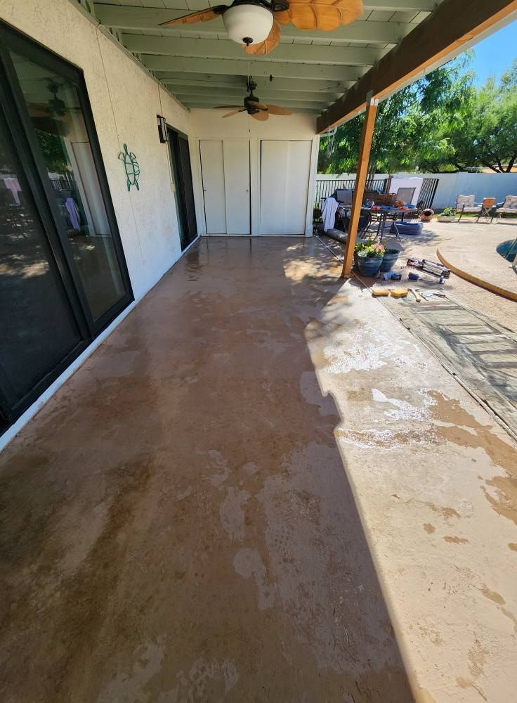 Covered patio with stained concrete floor, overlooking a pool area.