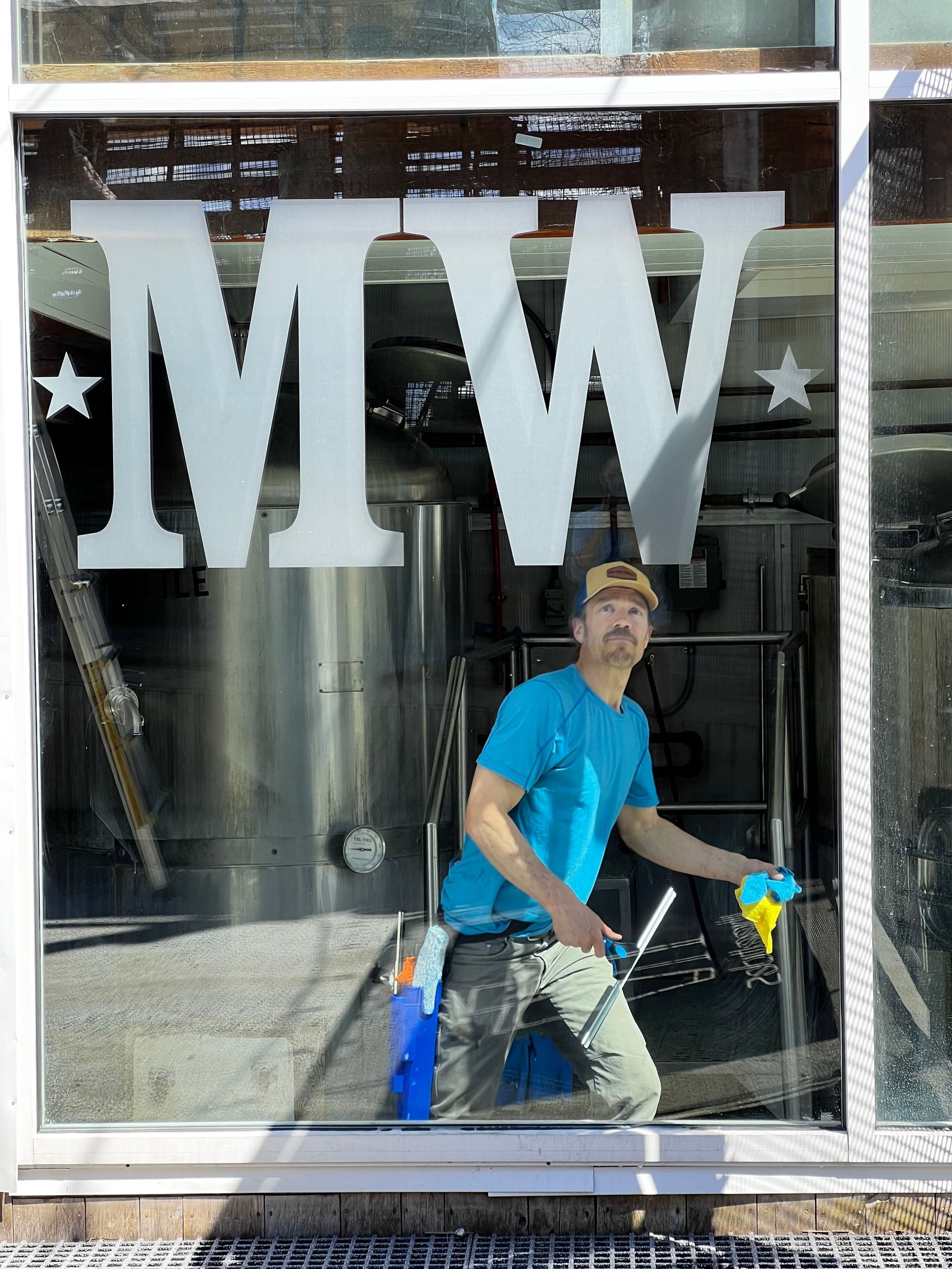 A light green HVAC unit stands in a dimly lit basement next to a water heater and a white washing machine.